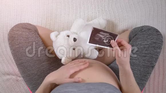持有胎儿超声波照片的孕妇视频的预览图