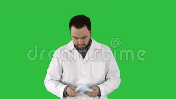 医生把面具和帽子戴在绿色屏幕上的肖像Chroma键视频的预览图