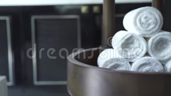 白色卷毛巾折叠在现代水疗沙龙在黑暗的背景深色浴室的白色浴巾视频的预览图