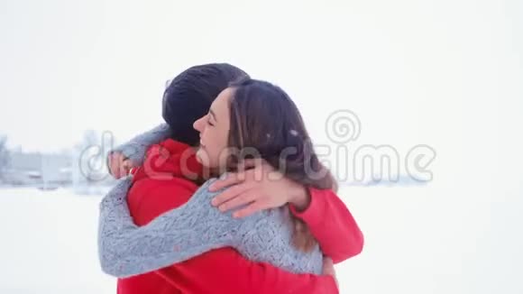 年轻快乐的男人拥抱他的女朋友恋爱中的感情伴侣在冬天的雪地里拥抱视频的预览图