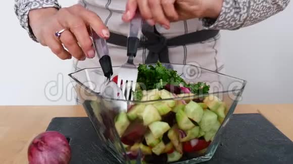 在餐桌上的玻璃碗中加入蔬菜沙拉视频的预览图