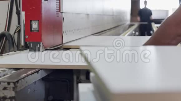 一家家具制造工厂的工人在机器上插入木板视频的预览图