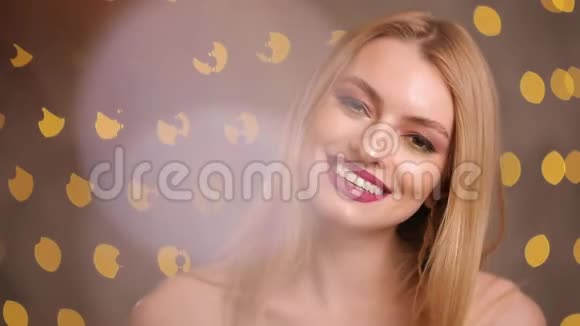 时尚模特微笑着看着黄色灯光下的相机慢镜头视频的预览图