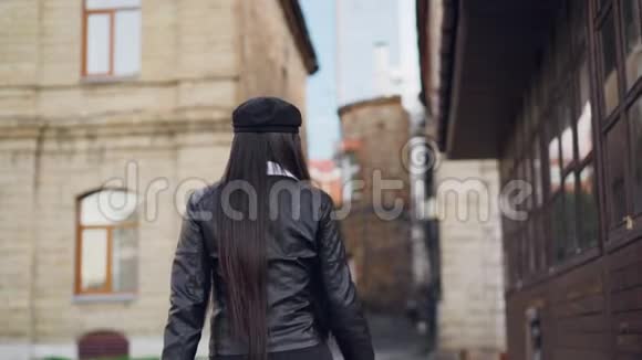 微笑的亚洲女人购物狂用纸袋走在街上转身看着她的慢镜头视频的预览图