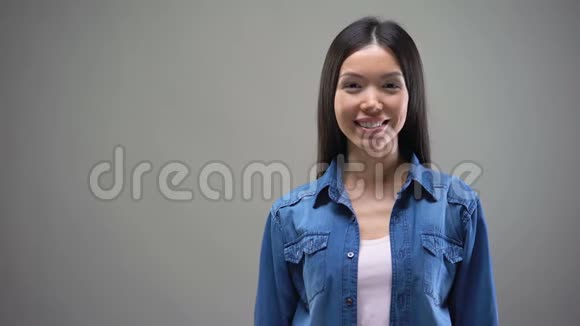 微笑的年轻亚洲女人站着双手交叉看着镜头视频的预览图