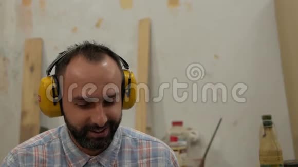 一个留着胡子的人用耳机听音乐唱歌视频的预览图