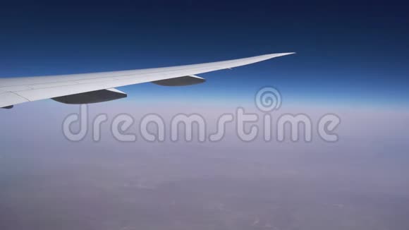 高空飞行在晴朗的天空和无尽的地平线上的飞机机翼视频的预览图