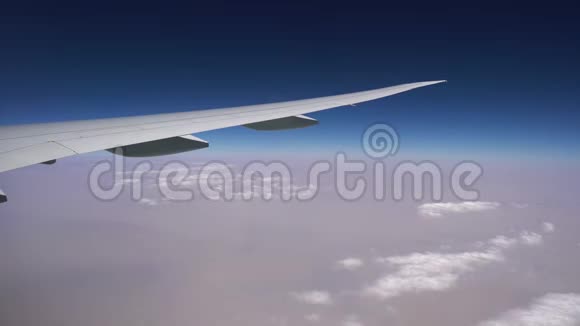 飞机在白云上方高空飞行窗户里飞机的机翼空中飞行视频的预览图