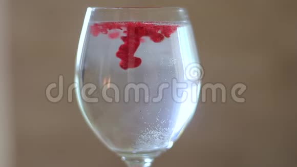 有红色油漆的水的玻璃杯视频的预览图