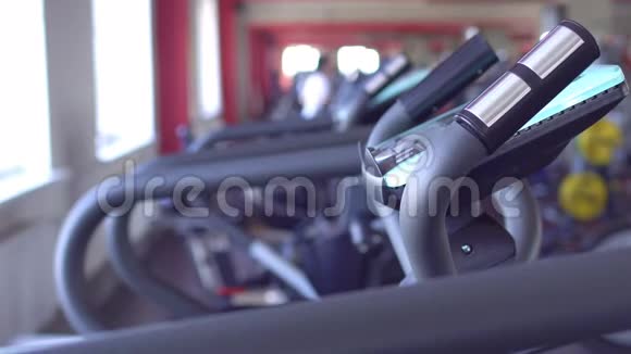 一个男人在健身房的跑步机上跑步背景模糊复制空间视频的预览图