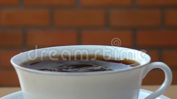 把咖啡倒进一个装满黑咖啡的白色杯子里视频的预览图