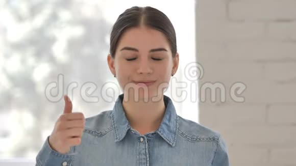 工作中的少女竖起大拇指看着镜头视频的预览图