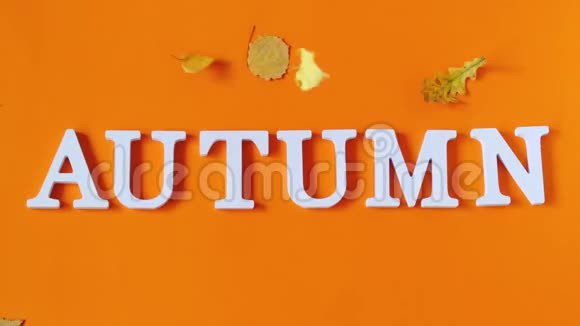 秋天的作文文字秋天从白色的字母和黄色的叶子落在橙色的纸背景上概念视频的预览图