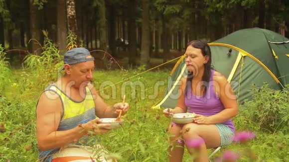男人和女人坐在森林里的帐篷附近吃水果沙拉视频的预览图