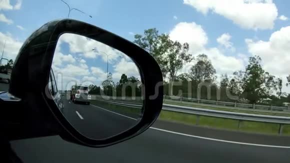 从汽车侧镜可以看到高速公路上的大型卡车视频的预览图