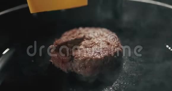 厨师准备汉堡在平底锅上用融化的奶酪煎肉铁板上炸芝士汉堡肉慢慢视频的预览图