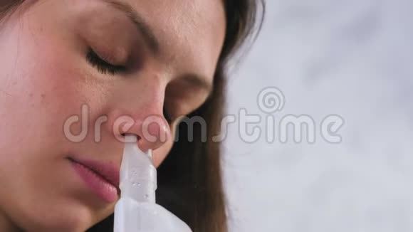 使用雾化器和吸入器进行治疗年轻女子用吸入器吸鼻子闭上脸视频的预览图