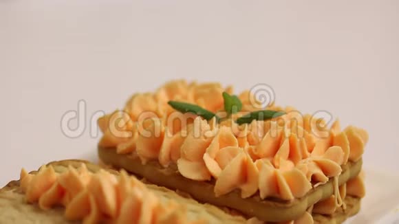 饼干和奶油蛋糕用薄荷叶装饰的特写镜头视频的预览图
