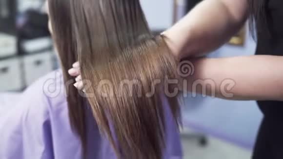 慢镜头拍摄特写一个年轻女孩的长发角蛋白矫直后的亮毛和丝质毛视频的预览图