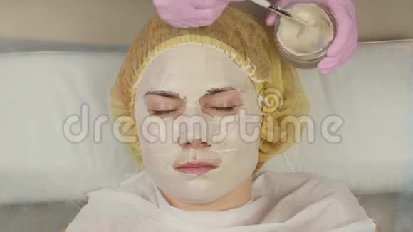 美容师把面膜敷在问题皮肤上年轻女子有皮肤清洁程序4K视频的预览图