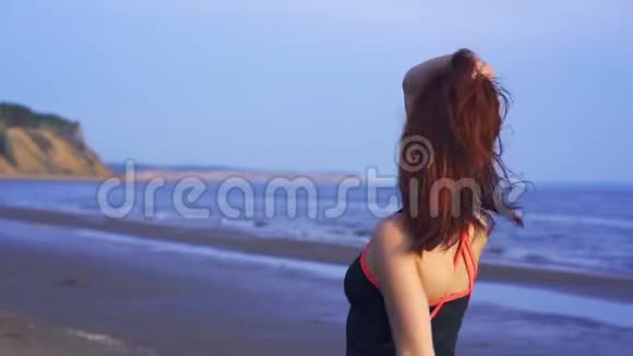 穿着运动服的红发中年妇女的肖像一位妇女在运动后沿着一条大河的沙岸散步视频的预览图