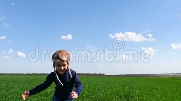 飞行员的孩子穿着套西装沿着绿色的田野奔跑双手缓慢地显示着飞机的飞行视频的预览图