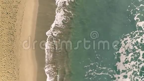 从上到下在沙滩上的海面上有许多脚印视频的预览图