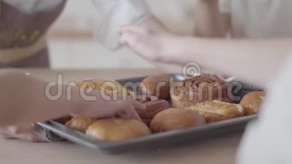 令人认不出的饥饿的儿子吃面包店友好的大家庭一起吃早餐吃甜食和橙汁视频的预览图