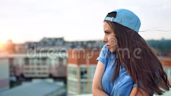 侧景肖像年轻迷人的少女戴着帽子享受美丽的日落户外视频的预览图