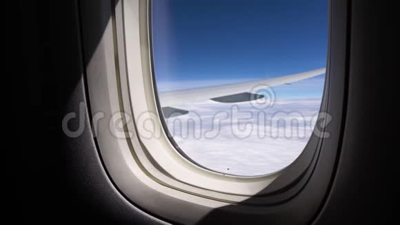 阳光透过飞机的窗户照射进来从乘客座位上俯瞰天空视频的预览图