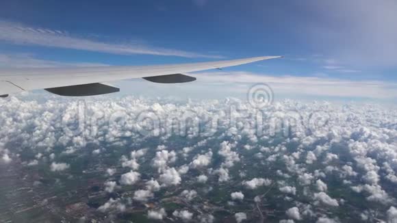 白色积云绿色的田野道路和飞机机翼下的建筑物视频的预览图