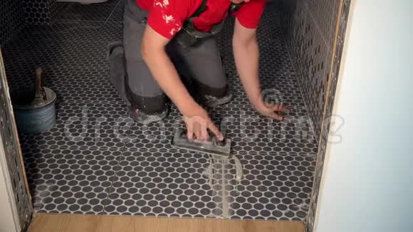 把赋格曲放在浴室地板上的工人瓷砖灌浆视频的预览图