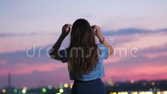 年轻女子举起双臂在空中放松欣赏美丽的猩红色天空视频的预览图