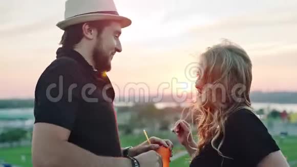 年轻的欧洲夫妇一起跳舞享受夏日屋顶派对的日落视频的预览图