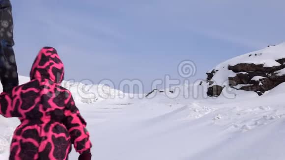 在一个寒冷的冬天母女俩在一条下雪的小路上爬上了山视频的预览图