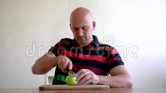 一个男人用苹果涂抹他的脸以恢复皮肤的活力脸上戴着苹果面具消除皱纹的方法视频的预览图