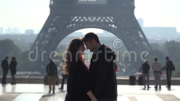 情侣们拥抱在埃菲尔铁塔前人们经过视频的预览图