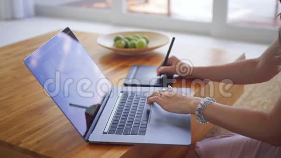 女性手在电脑和绘图垫上工作视频的预览图