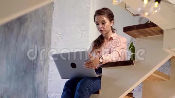 女孩在家里用她的笔记本电脑库存录像在家工作的年轻女性视频的预览图