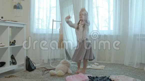 穿着成年妈妈的衣服衣服高跟鞋在镜子前跳舞的快乐女孩妈妈们视频的预览图