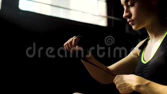 特写年轻漂亮的女人坐在地板上用黑色拳击包手在俱乐部里视频的预览图