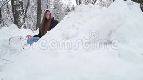 一位年轻的女士在一个冬天白雪覆盖的公园里的长凳上抽烟约克郡猎犬靠近主人的脚少年和狗视频的预览图