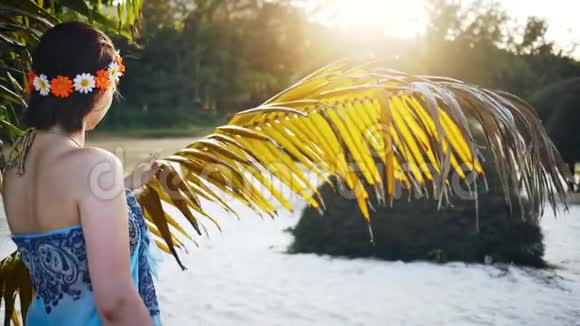 一个女孩抚摸一棵干枯的棕榈树视频的预览图