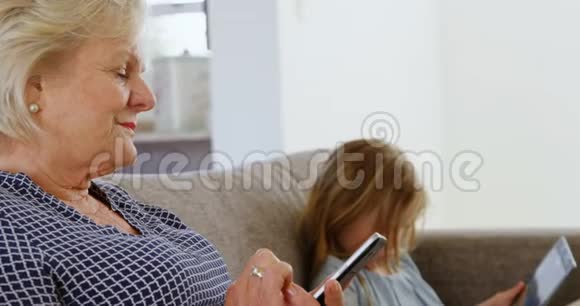 祖母和孙女使用手机和数码平板电脑视频的预览图