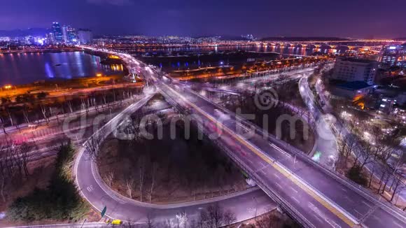 时间流逝的桥梁和汽车在十字路口汉河边在夜间首尔市中心韩国4K视频的预览图