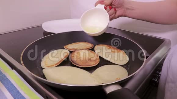 女人用煎饼在锅上加油视频的预览图