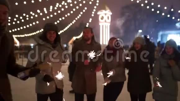 在圣诞市场上快乐的朋友手里拿着星星之火开派对人们在新年跳跳舞视频的预览图