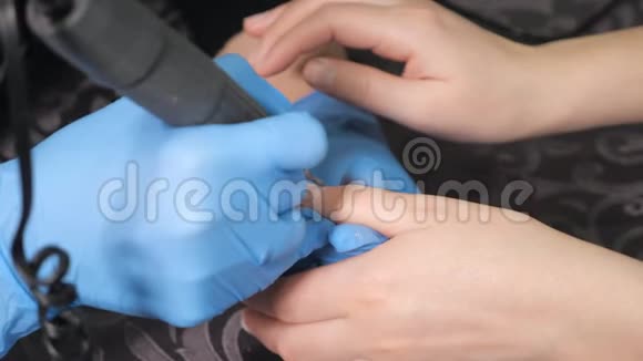 美甲师正在用电动指甲锉钻对女性手指进行美甲视频的预览图