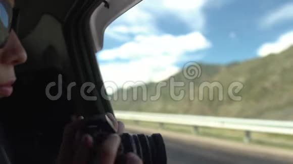 美丽的亚洲女孩戴着黑色太阳镜乘坐敞篷车旅行时用老式相机在山上拍照视频的预览图