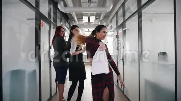 一位情绪激动的商界女性在办公室走廊上与同事跳舞视频的预览图